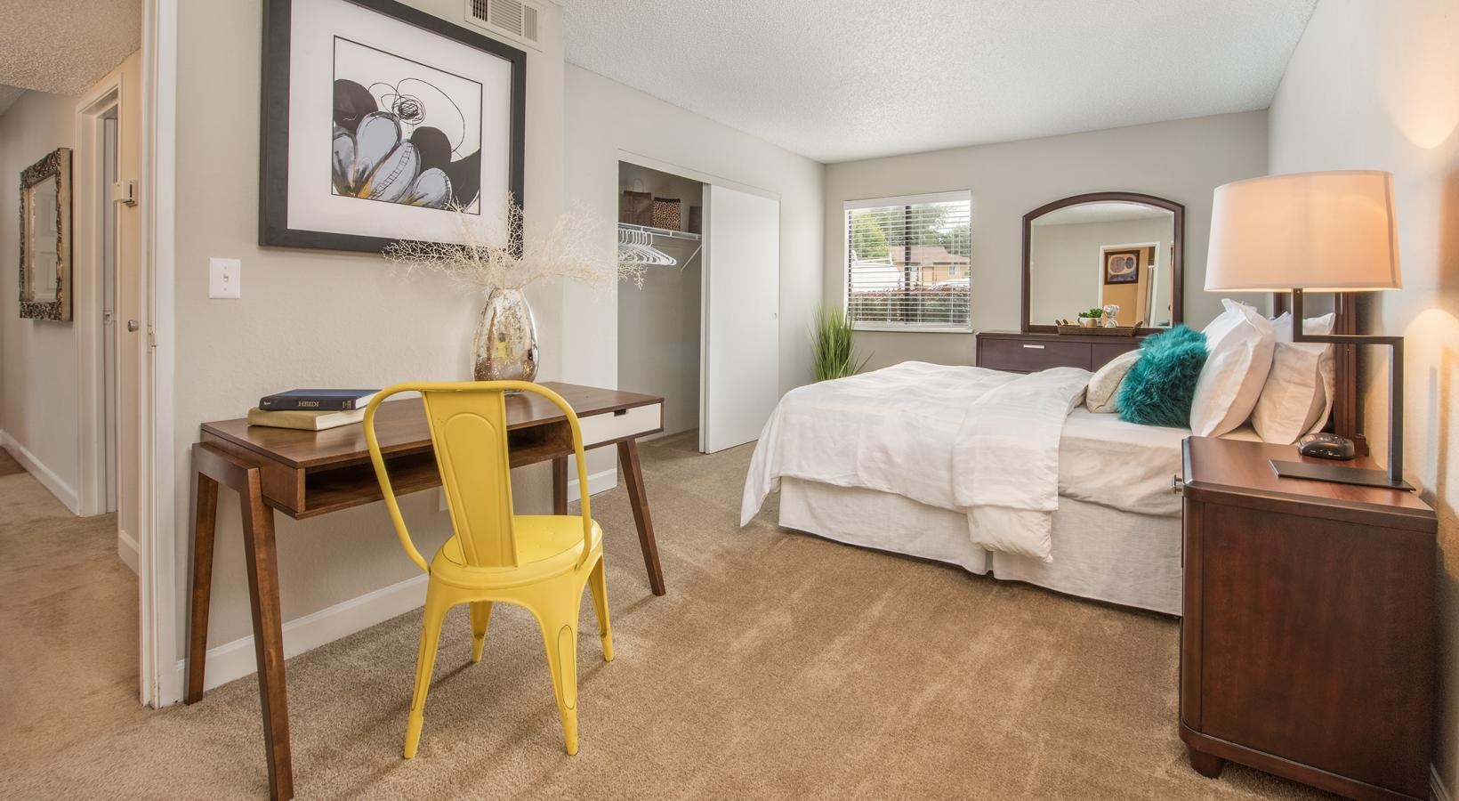 Relax and recharge in beautiful and spacious bedrooms a bedroom with a bed desk and a chair