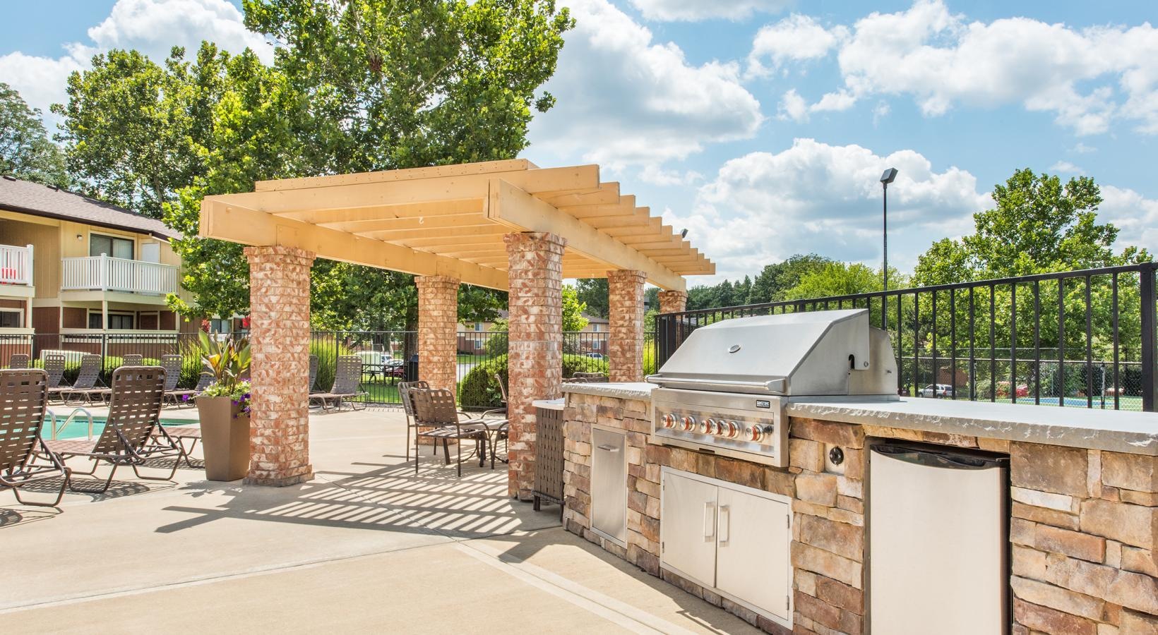 Settle into comfort at The Lodge of Overland Park a patio with a covered area and a grill