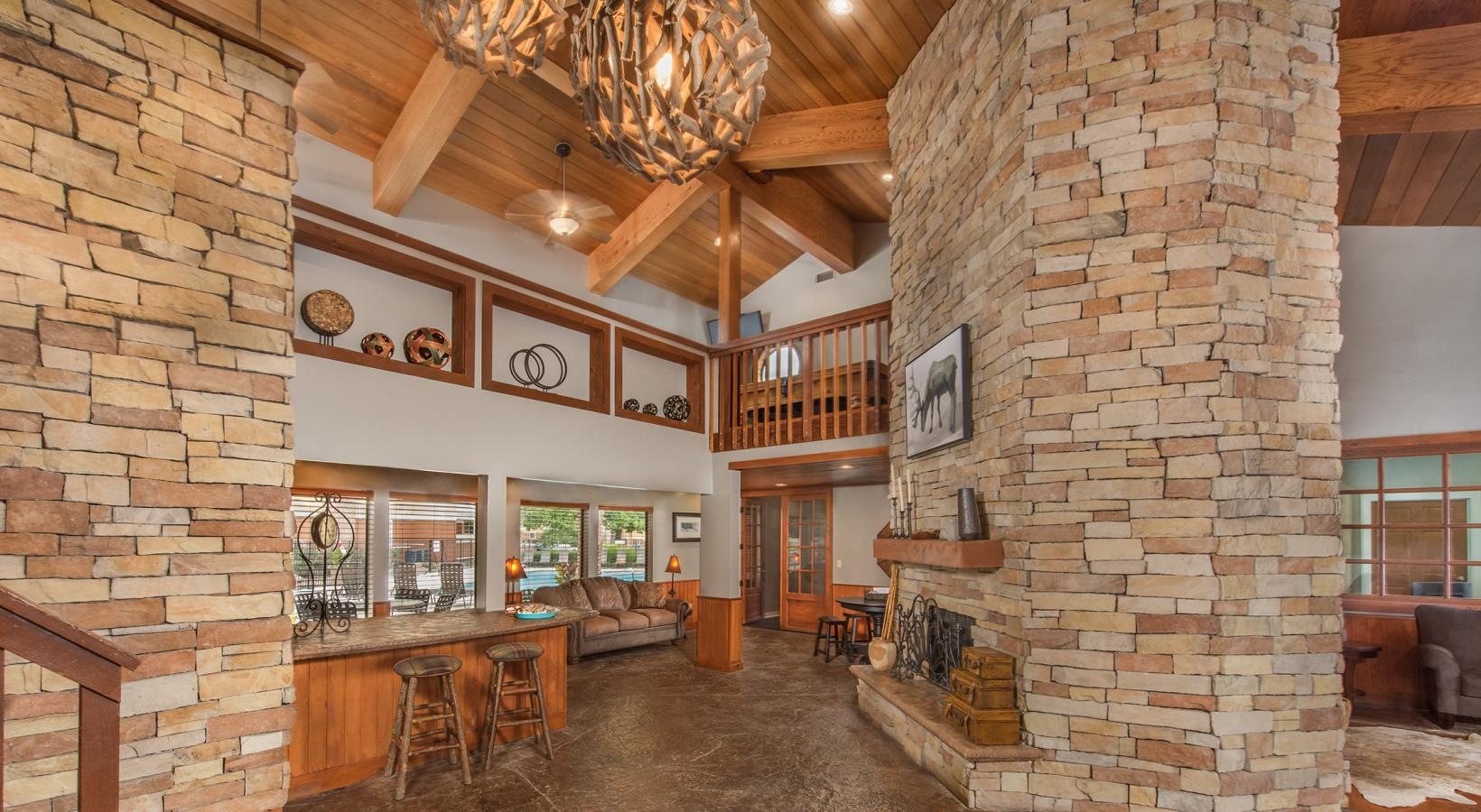 Close to the center of everything a room with a stone wall and a bar with a table and chairs