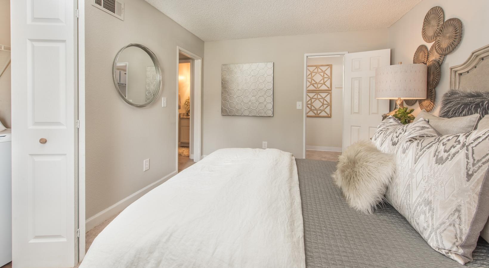 Generous bedroom offerings to fit every family a bedroom with a bed and a mirror