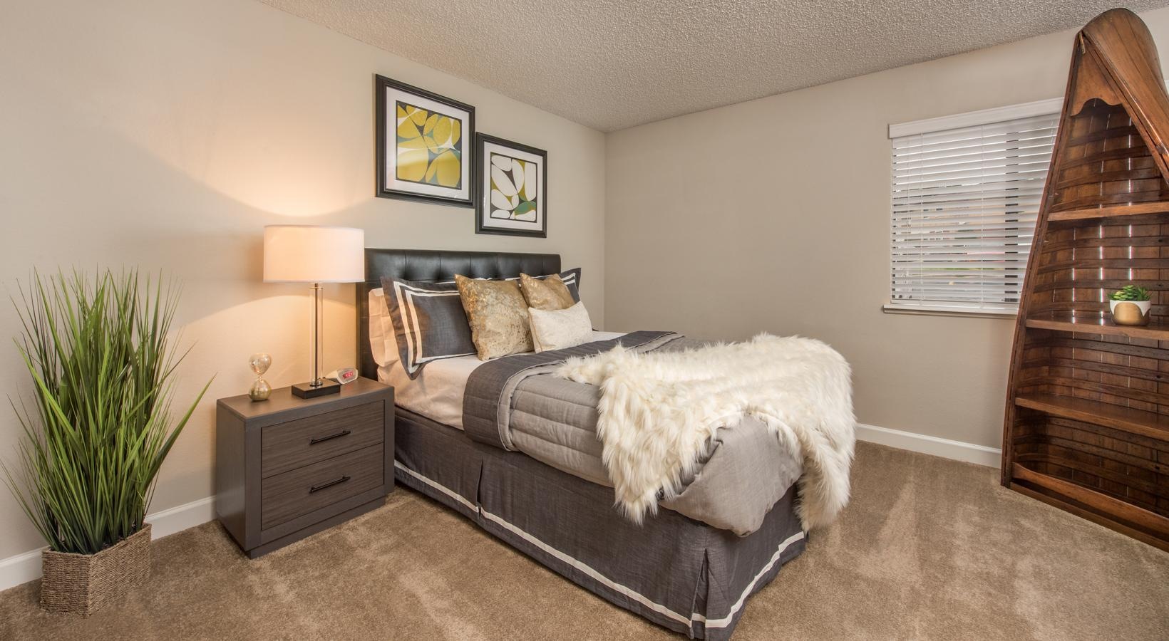 Generous bedroom offerings to fit every family a bedroom with a bed and sidetable and a lamp