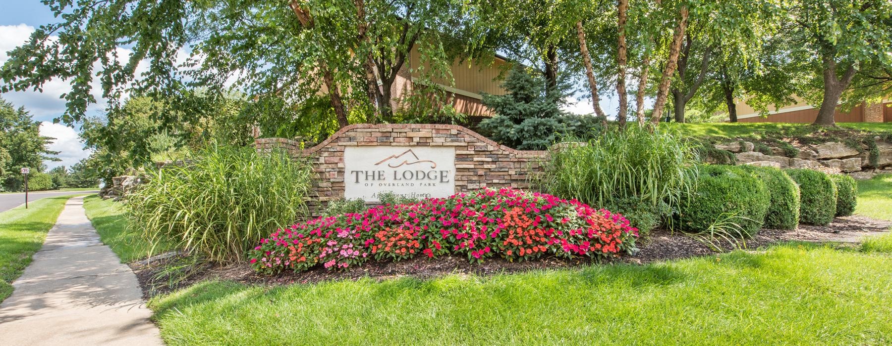 a sign in a garden that reads the lodge